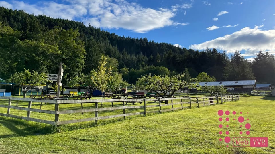 A pasture, apple trees, fencing and a barn and the DWebYVR logo in the bottom right corner